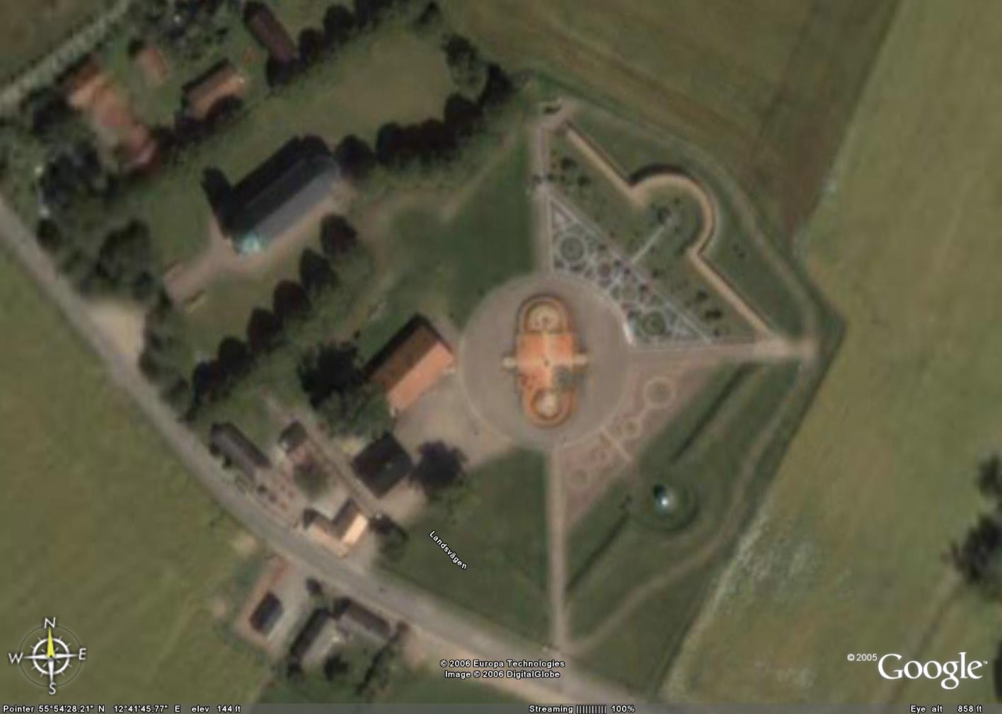 Ruínas de Uraniborg, o Castelo Celeste de Tycho Brahe, como seria avistado de uma altitude de 279 metros. Note que as alamedas principais do castelo se alinham perfeitamente com os pontos cardeais, indicados no canto inferior esquerdo da imagem. Pode-se ver, espalhados pelo castelo, configurações circulares — pequenas praças —, onde os instrumentos astronômicos eram posicionados.